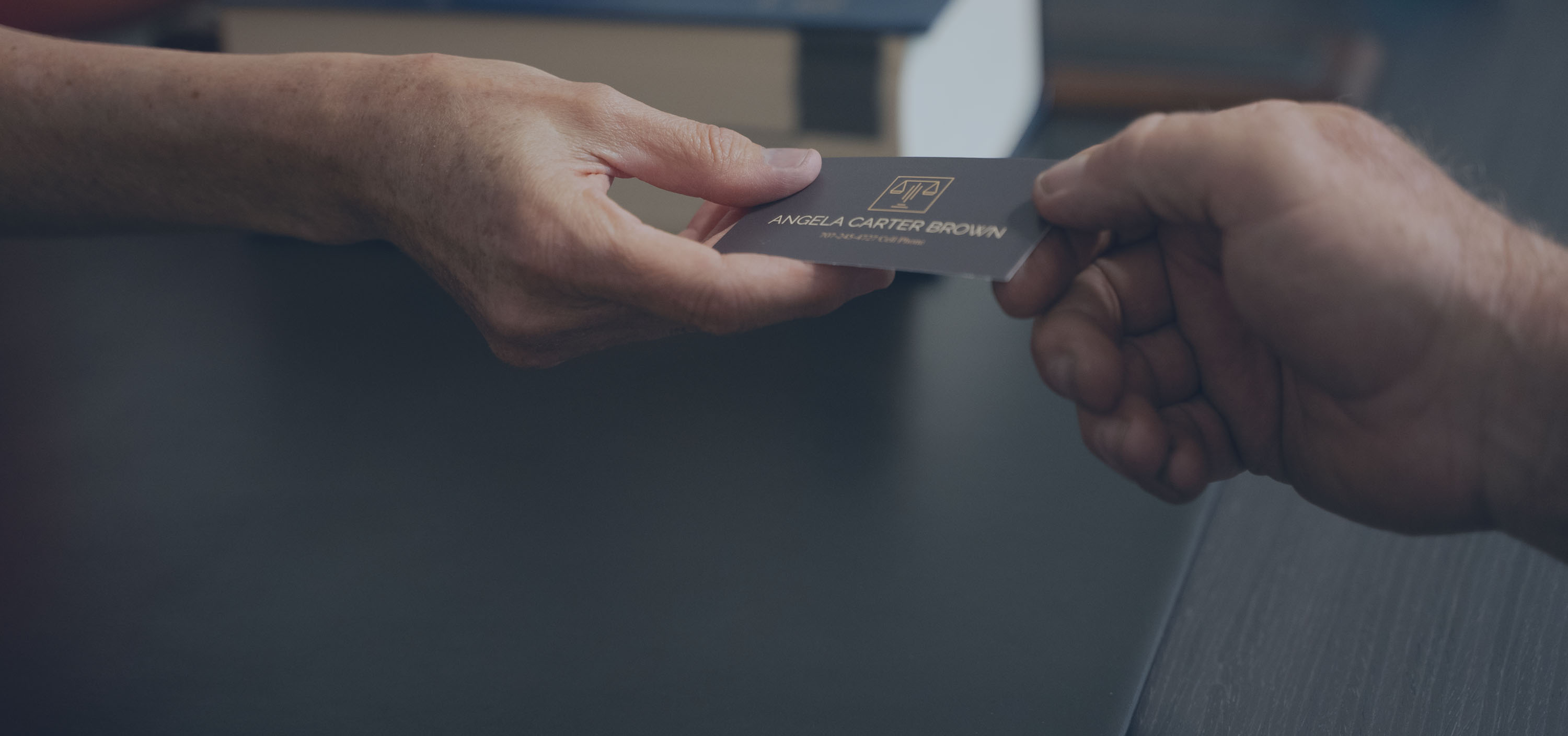 Image of Angela Carter Brown passing a business card